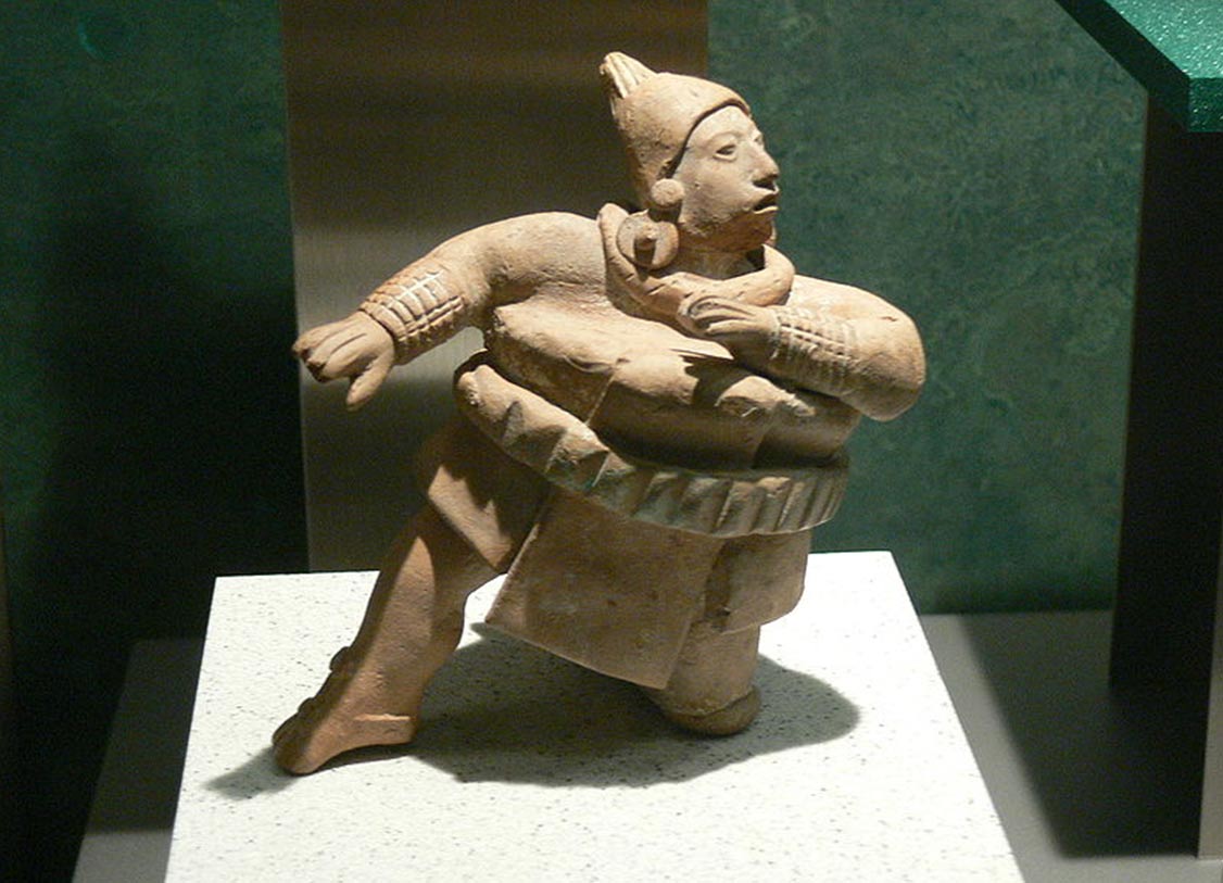 Estatuilla de un jugador de pelota luciendo gruesa ropa acolchada (Wikimedia Commons)