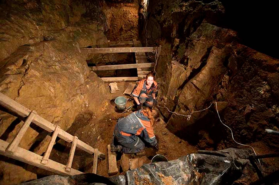 Los investigadores trabajan en el interior de la cueva de Denisova. (Vera Salnitskaya/The Siberian Times)