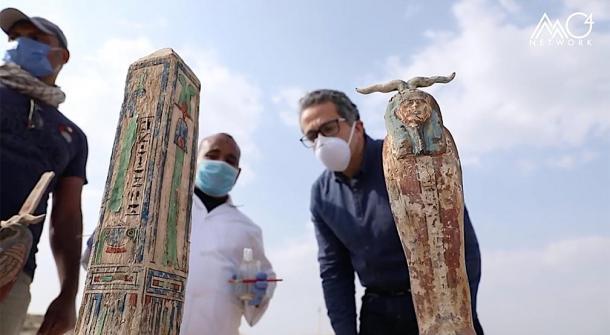 Los arqueólogos y Khaled El-Enany inspeccionan el antiguo obelisco egipcio y otra figura desenterrada en el sitio arqueológico de Saqqara. (Ministerio de Turismo y Antigüedades de Egipto)