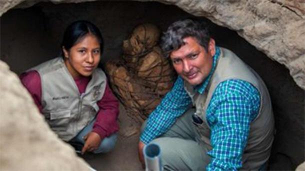 El arqueólogo Pieter Van Dalen Luna, de la Universidad Estatal de San Marcos, Perú, a la derecha, con la momia atada con una cuerda justo detrás de él. (UNMSM)