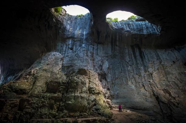 'Los ojos' en la cueva de Prohodna con restos de agua de lluvia goteando por las paredes. (Lucian Bolca / Adobe Stock)