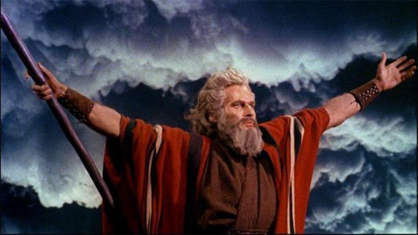 Charlton Heston como Moisés en "Los Diez Mandamientos" (1956), levantando los brazos mientras separa las aguas del Mar Rojo en una pose clásica de magos y sacerdotes egipcios. (Dominio publico)