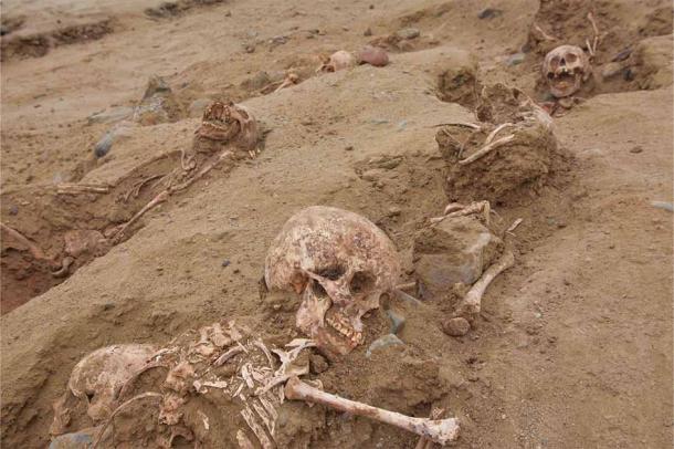 Un esqueleto de sacrificio de un niño recientemente desenterrado, en la parte inferior de esta imagen, es vívido y los dientes son todos perfectos. (Programa Arqueológico andina / Huanchaco)